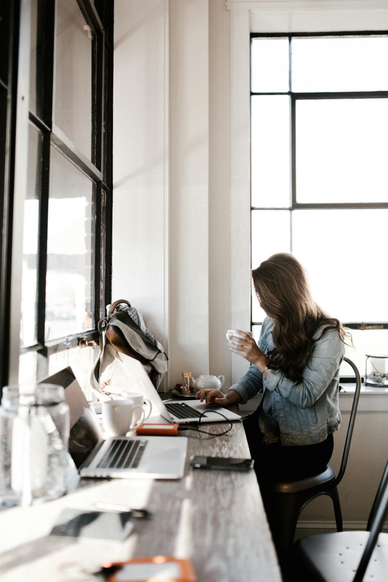 Woman in Gray Jacket Sitting Beside Desk